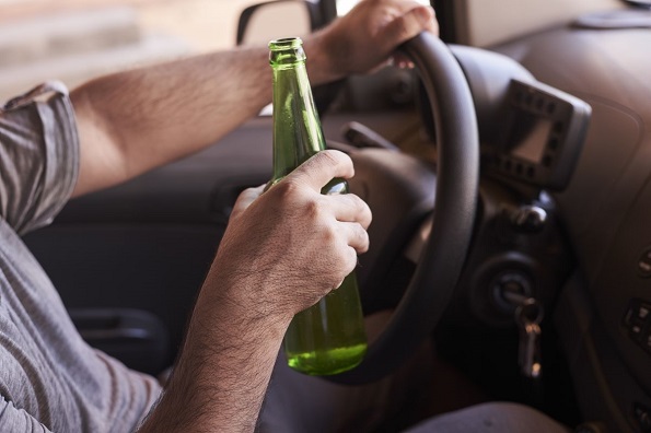 Водитель пьет алкоголь за рулем